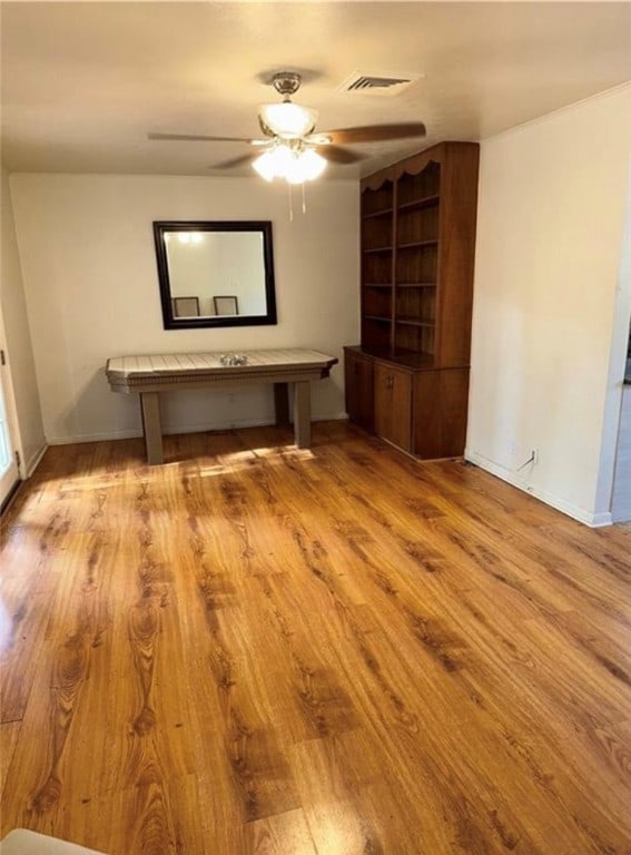 empty room with ceiling fan and light hardwood / wood-style flooring