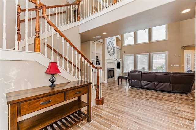 7601 Dijon Lake Dr, Corpus Christi, TX 78413 - stairs featuring a high ceiling, a fireplace, wood finished floors, and recessed lighting