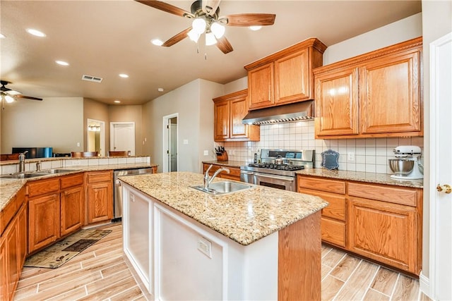 7601 Dijon Lake Dr, Corpus Christi, TX 78413 - kitchen featuring ceiling fan, stainless steel appliances, wood finish floors, recessed lighting, and a kitchen island with sink