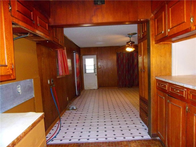 kitchen with ceiling fan and wooden walls