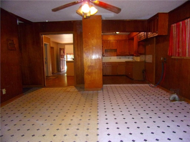 kitchen featuring wood walls and ceiling fan