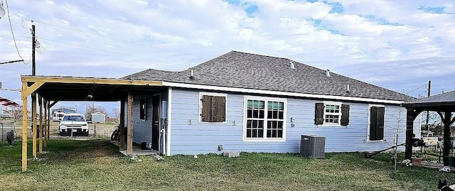 back of house featuring central air condition unit and a yard