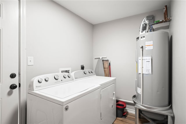 clothes washing area with electric water heater, hardwood / wood-style flooring, and washer and clothes dryer