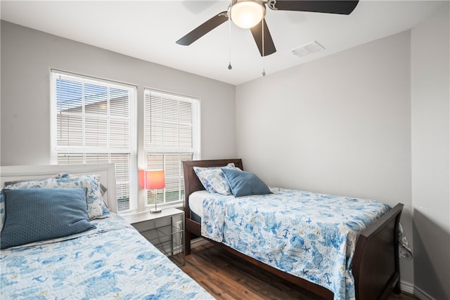 bedroom featuring dark hardwood / wood-style floors, ceiling fan, and multiple windows