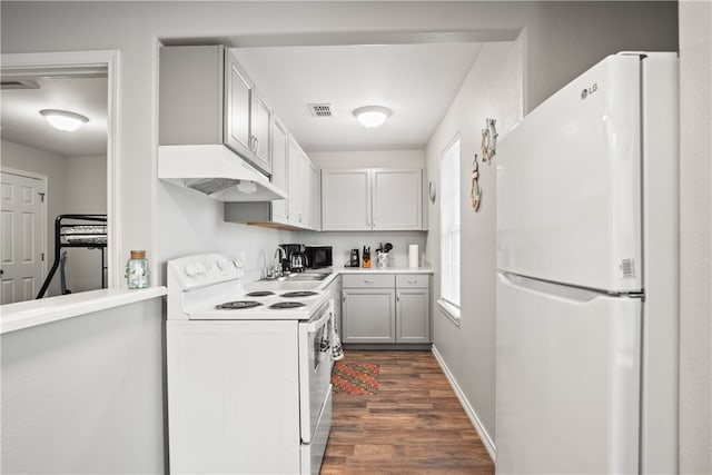 kitchen with dark wood-type flooring, white appliances, sink, and white cabinets