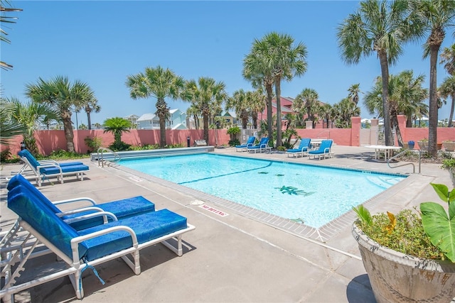 community pool with fence and a patio