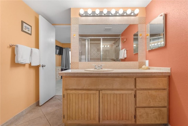 bathroom with a stall shower, vanity, visible vents, and tile patterned floors