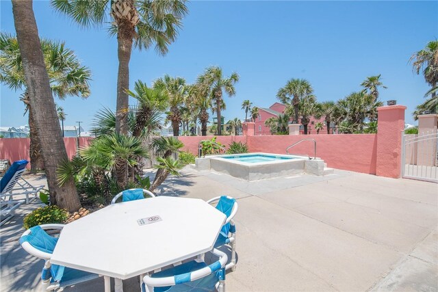 view of swimming pool featuring a community hot tub, a patio area, and a fenced backyard