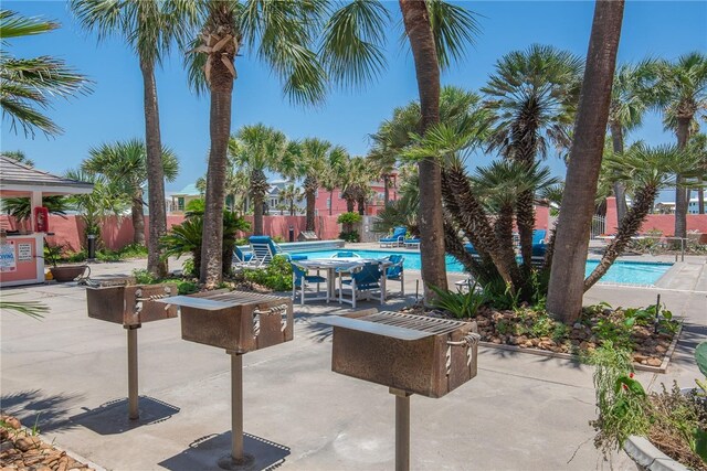 view of patio / terrace featuring a community pool and fence