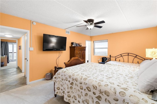 bedroom featuring carpet floors, visible vents, a textured ceiling, and multiple windows