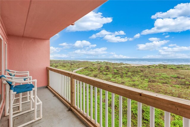 balcony featuring a water view and a beach view