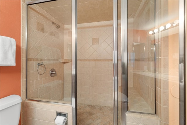 bathroom with a shower stall and toilet