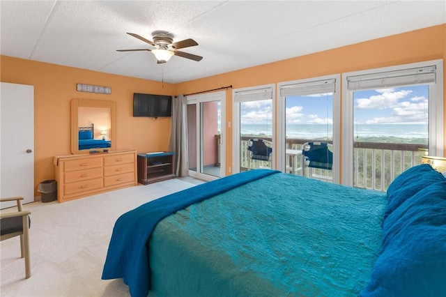 carpeted bedroom with a textured ceiling, access to outside, and a ceiling fan