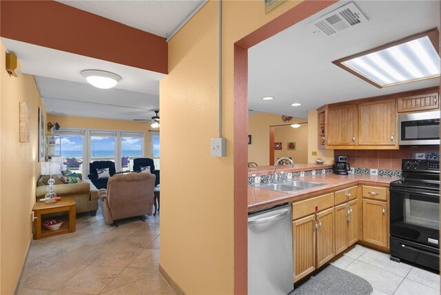 kitchen with stainless steel appliances, a sink, visible vents, a ceiling fan, and open floor plan