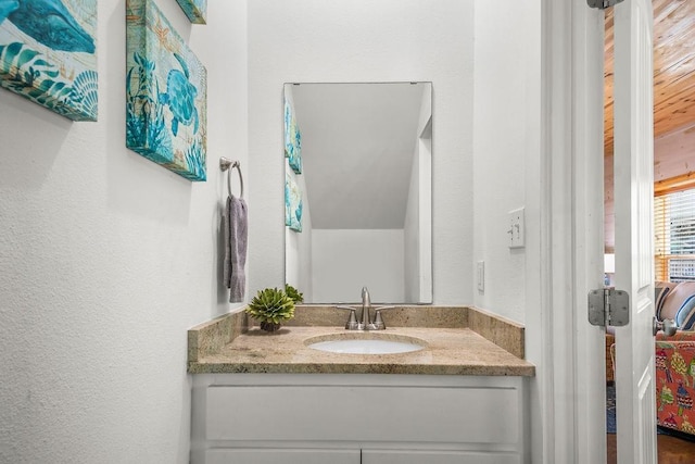 bathroom with vanity and a textured wall