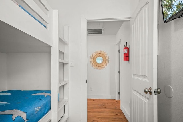 bedroom featuring visible vents, baseboards, and wood finished floors