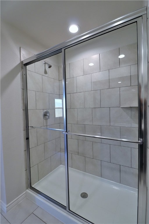 bathroom with tile patterned flooring and a shower with door