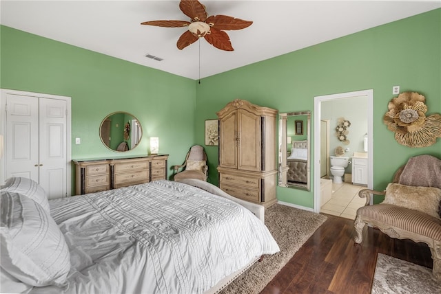 bedroom featuring connected bathroom, a closet, light hardwood / wood-style floors, and ceiling fan