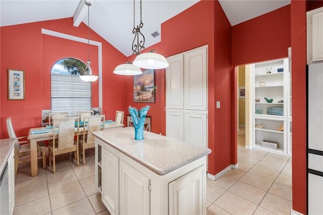 kitchen with hanging light fixtures, white cabinetry, light tile patterned floors, and lofted ceiling with beams