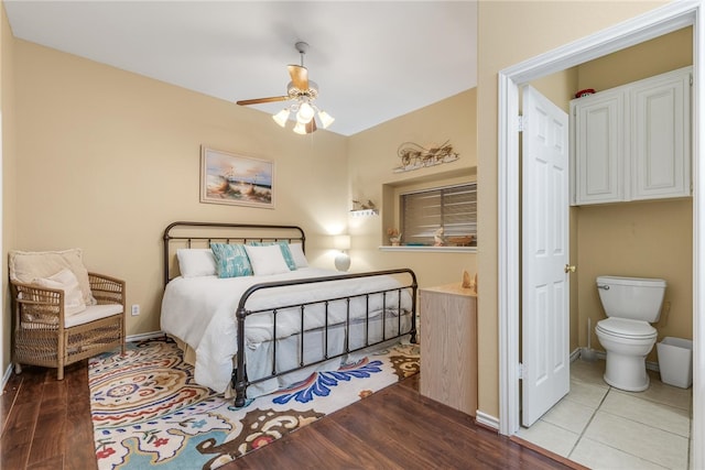 bedroom with ceiling fan, ensuite bath, and wood-type flooring