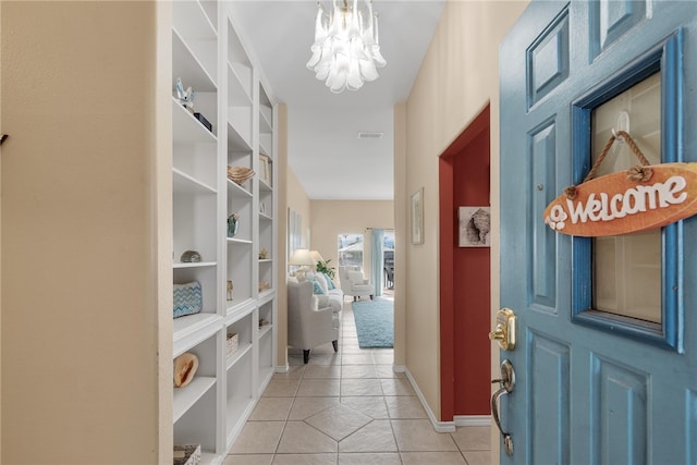 corridor featuring a notable chandelier and light tile patterned floors