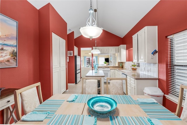 kitchen featuring white stove, fridge, decorative light fixtures, and white cabinets