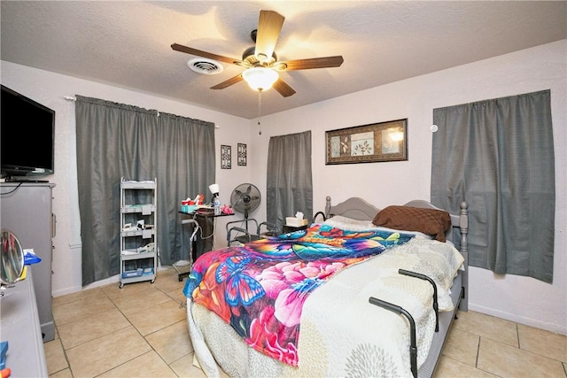 bedroom with a textured ceiling, ceiling fan, and light tile patterned floors