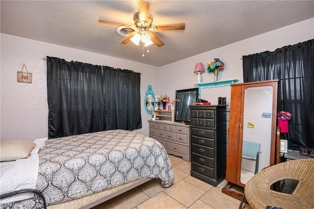 bedroom featuring ceiling fan, a textured ceiling, and light tile patterned floors