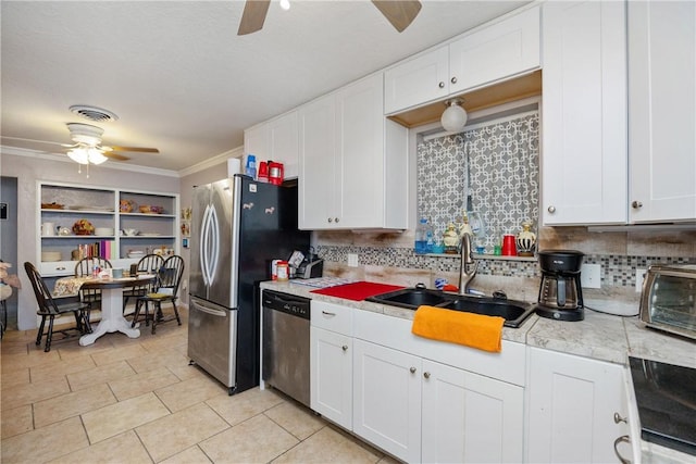 kitchen with stainless steel appliances, crown molding, sink, white cabinetry, and tasteful backsplash