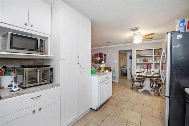 kitchen with stainless steel appliances, white cabinets, ornamental molding, and ceiling fan