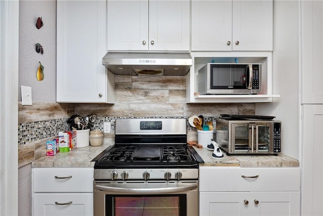 kitchen with appliances with stainless steel finishes, backsplash, and white cabinetry