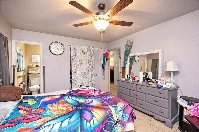 tiled bedroom featuring ensuite bath and ceiling fan