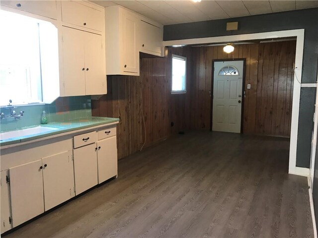 1222 18th St, Corpus Christi, TX 78405 - kitchen with wood walls, white cabinets, light wood-style flooring, plenty of natural light, and decorative backsplash