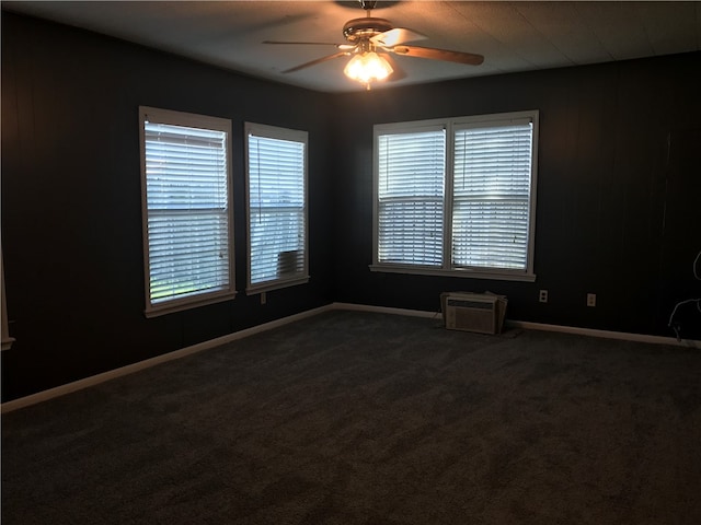 carpeted empty room featuring a wall unit AC and ceiling fan