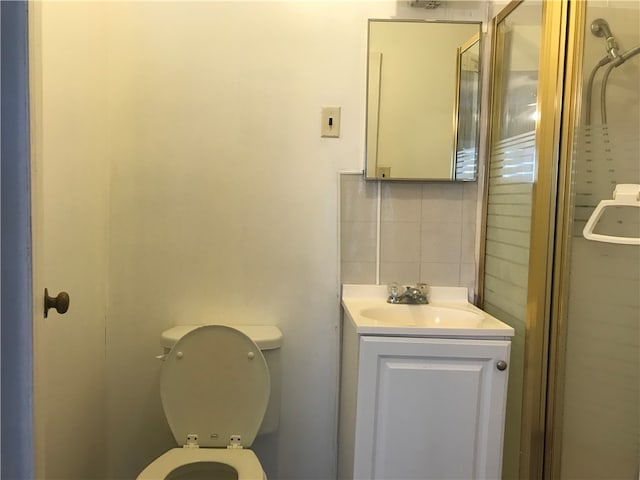 bathroom with vanity, toilet, and backsplash