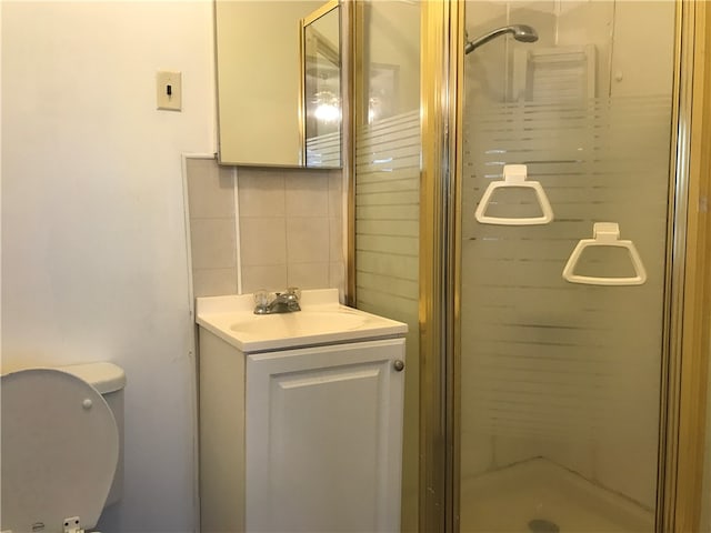 bathroom featuring walk in shower, toilet, vanity, and tasteful backsplash