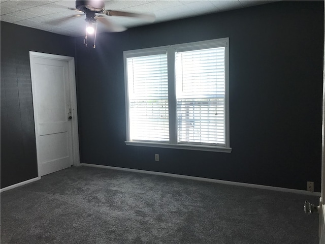 carpeted spare room featuring a wealth of natural light and ceiling fan