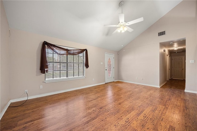 spare room with baseboards, visible vents, ceiling fan, wood finished floors, and high vaulted ceiling