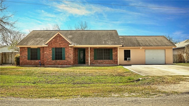 ranch-style home featuring brick siding, an attached garage, fence, driveway, and a front lawn