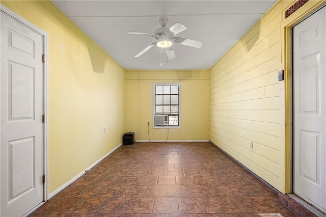 spare room featuring ceiling fan and baseboards