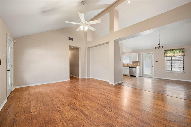 unfurnished living room with light wood finished floors, ceiling fan, visible vents, and a wealth of natural light