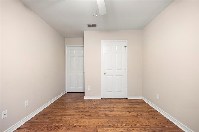 unfurnished bedroom with a ceiling fan, wood finished floors, visible vents, and baseboards