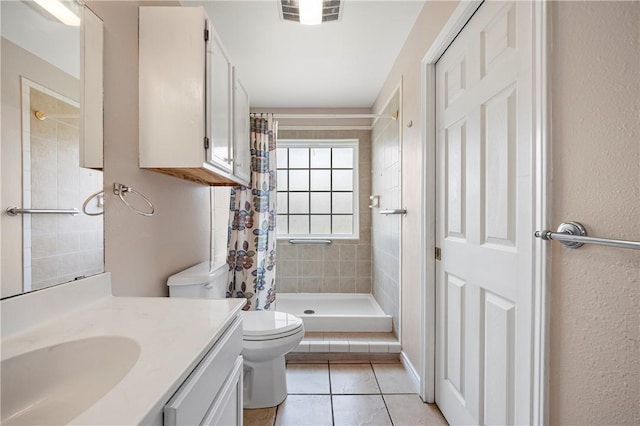 full bathroom featuring tile patterned flooring, toilet, vanity, visible vents, and a stall shower