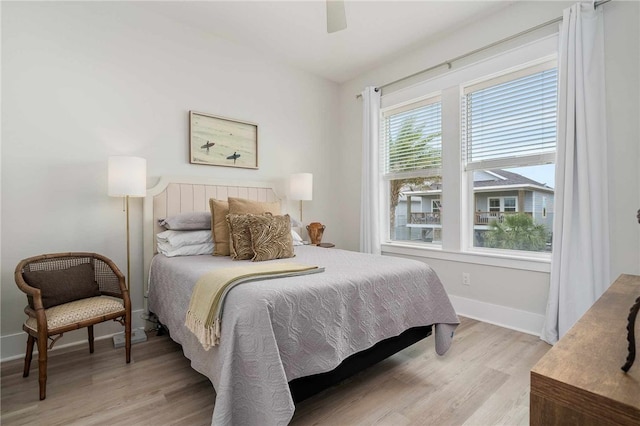 bedroom with multiple windows, ceiling fan, and light wood-type flooring