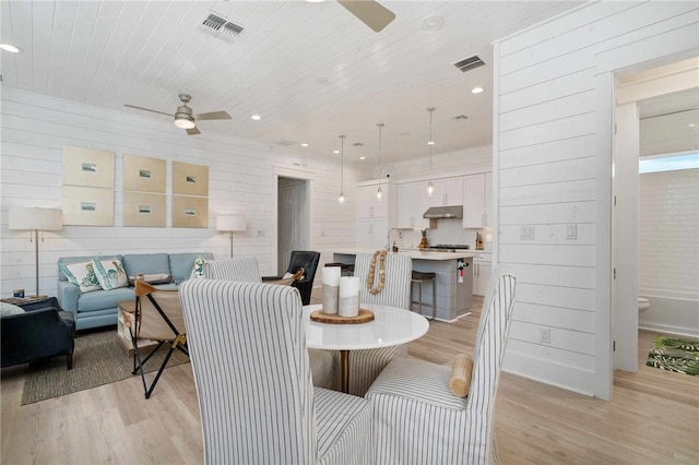 dining space featuring ceiling fan, sink, wooden ceiling, and light hardwood / wood-style floors