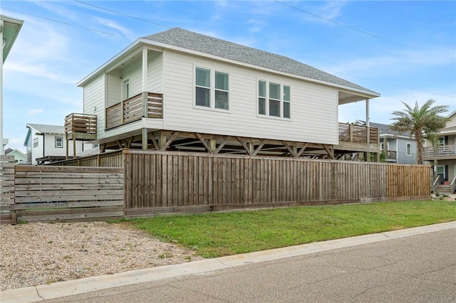 view of front of property with a balcony and a front lawn