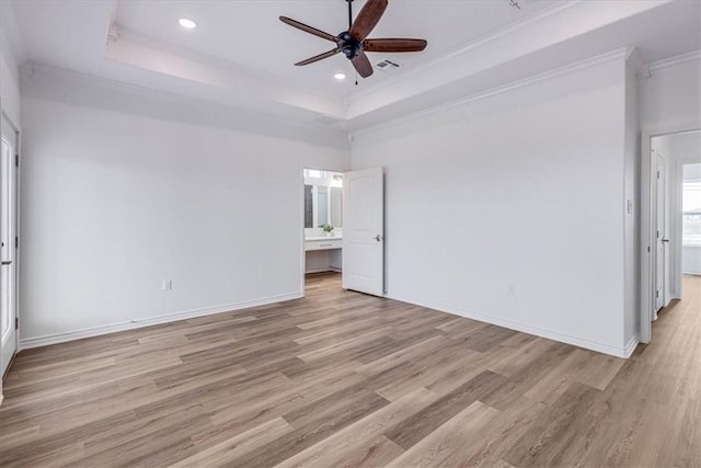 unfurnished bedroom featuring crown molding, a raised ceiling, and light hardwood / wood-style flooring