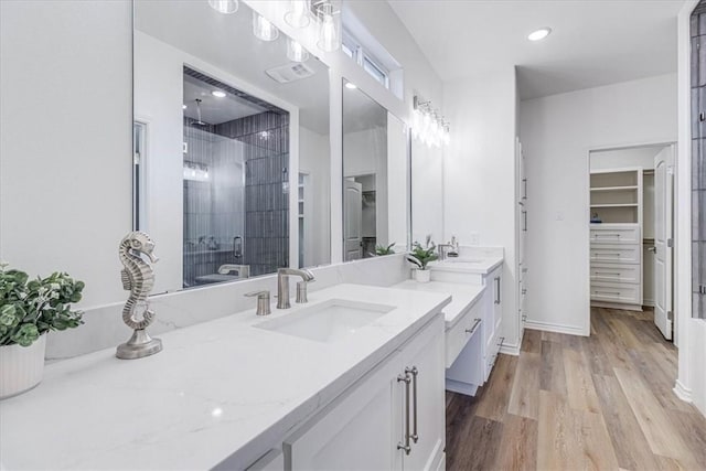 bathroom with vanity, a shower with shower door, and wood-type flooring