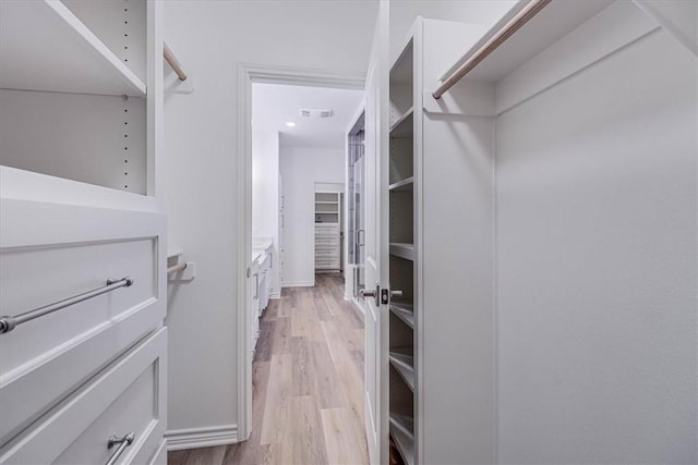 spacious closet with light hardwood / wood-style flooring