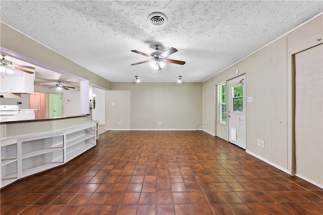 unfurnished living room with dark tile patterned flooring and a textured ceiling